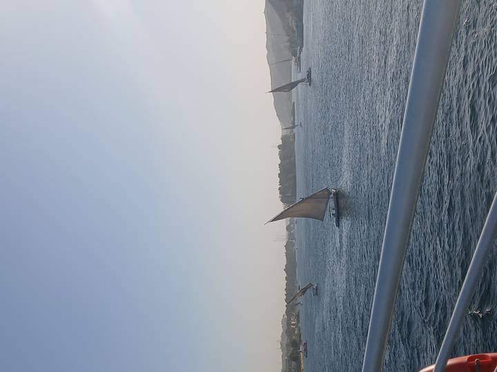 Traditional feluccas with canvas sails glide across the calm Nile at dusk.