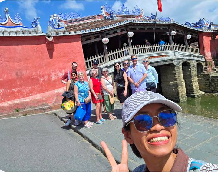 Selfie of tour group in front of the red Japanese Covered Bridge in Hoi An.