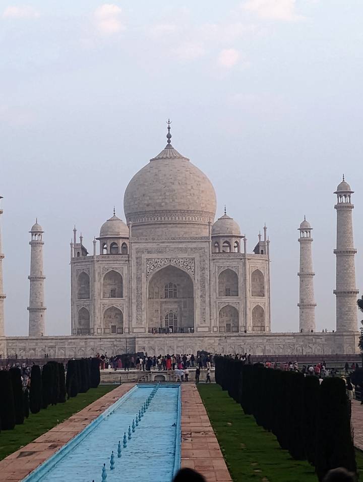 Classic frontal view of the Taj Mahal's white marble mausoleum under pale evening light.