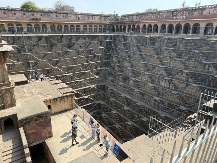Breathtaking view down into Chand Baori stepwell with its intricate symmetrical stair patterns.
