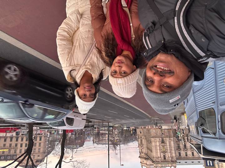 Family selfie while strolling an urban European street on a chilly grey morning.