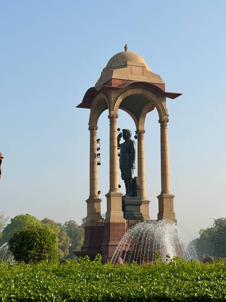 Statue beneath ornate sandstone canopy monument on Rajpath, New Delhi