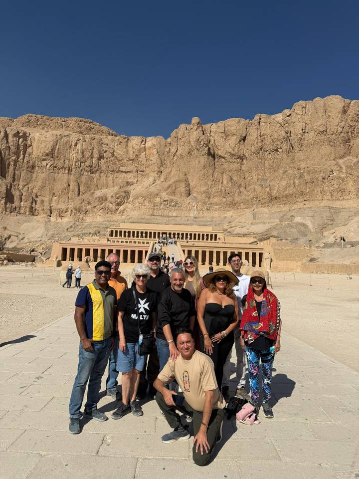 Tour group posing in front of the grand colonnades of the Temple of Hatshepsut in Luxor.