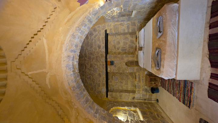 Cozy stone-arched desert lodge bedroom with warm lighting and rustic décor