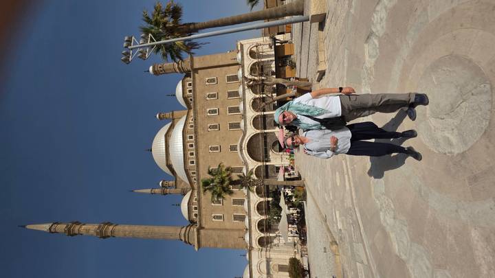 Travellers standing before the grand Mohammed Ali Mosque with tall minarets and central dome in Cairo