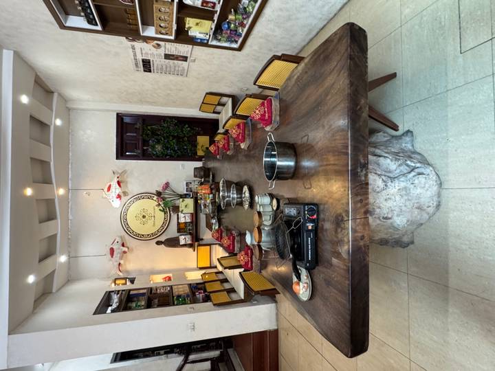 Long rustic table set with bowls, burners and ingredients prepared for a group cooking lesson.