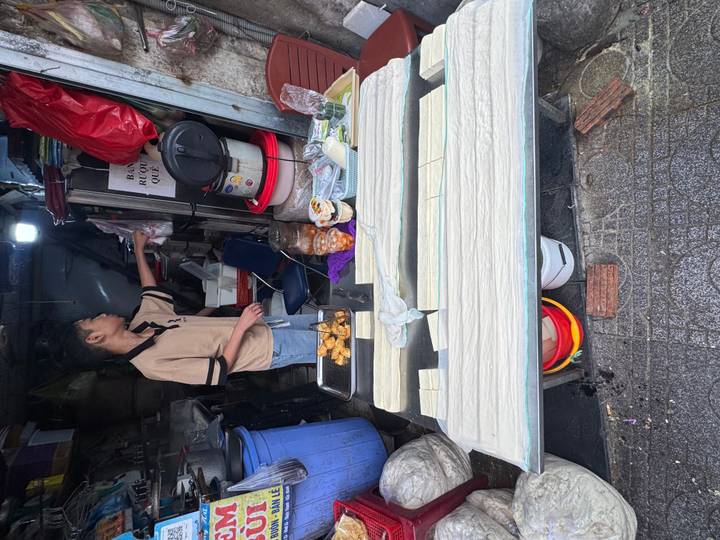 Street vendor preparing golden fried snacks at a compact roadside stall.