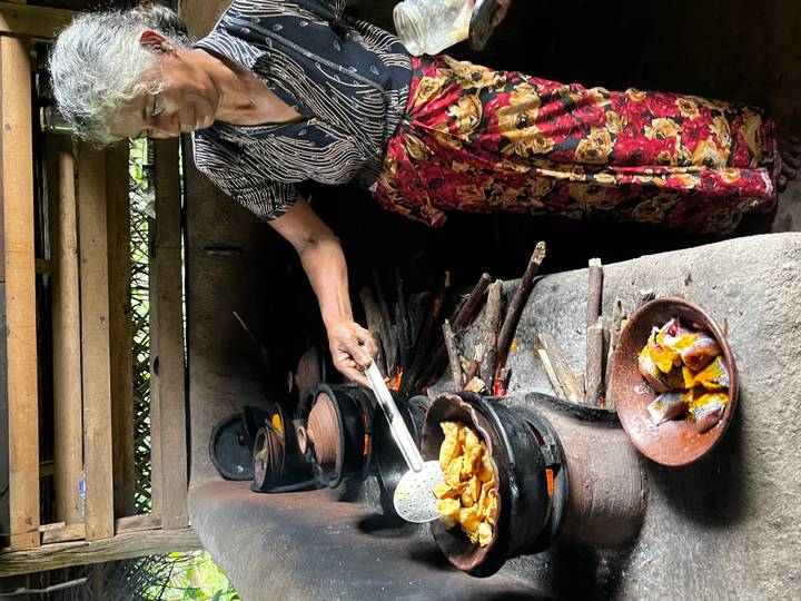 Sri Lankan woman cooks curry over traditional clay stoves fueled by wood.