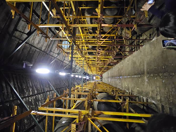 Long aisle between tall racks of whisky barrels inside a dim distillery warehouse