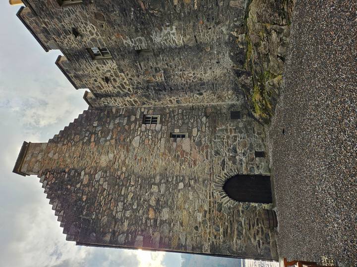 Close view of rugged stone castle walls and arched wooden doorway