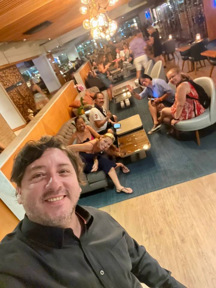 Blurry selfie of travelers relaxing on couches in a hotel lobby.