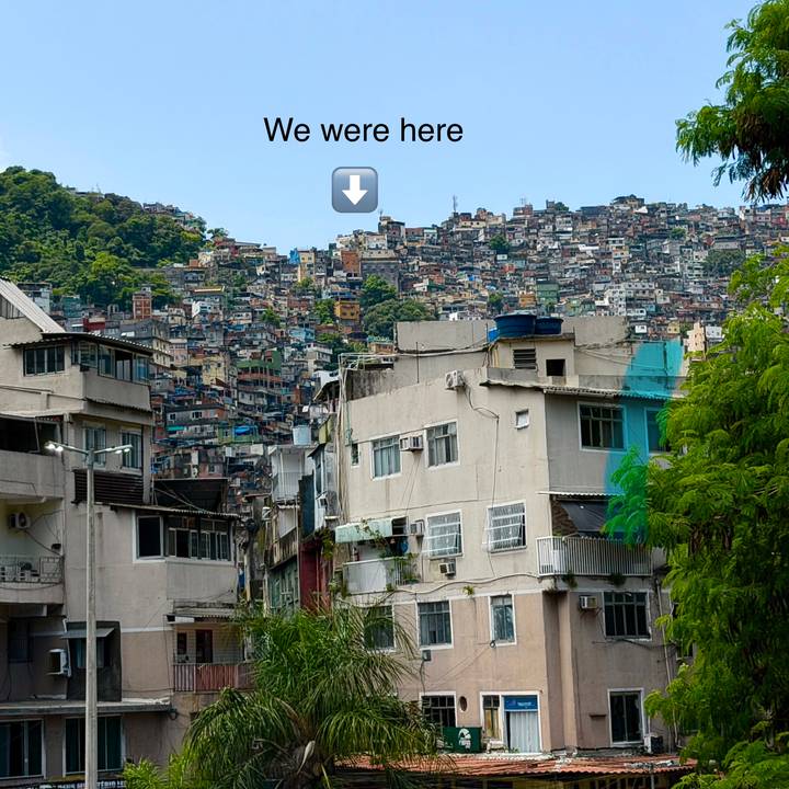 Dense hillside favela with stacked colorful houses; a graphic arrow overlay appears at top center.
