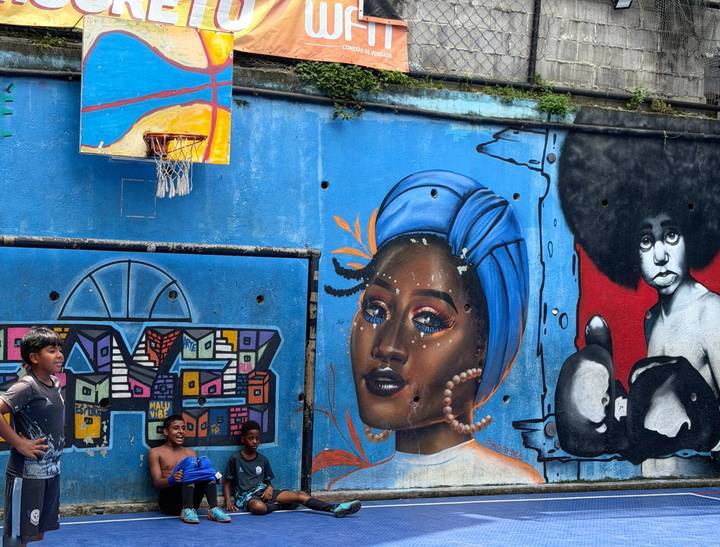 Colorful street mural with boys playing basketball beneath a bright backboard.