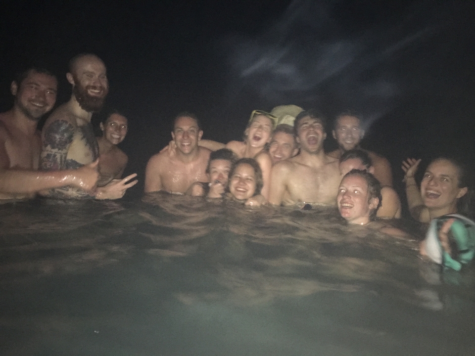 A group of people swimming at night, having fun.