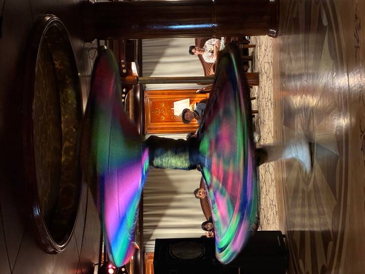 Long-exposure whirling dervish performance aboard Nile cruise ship creating colourful spinning blur