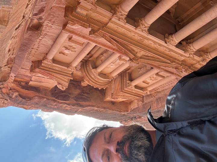 Traveller’s selfie partially framing Petra’s famous Treasury carved into red cliffs