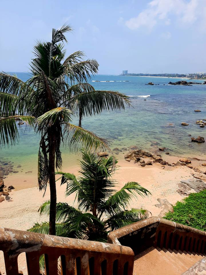 Palm-fringed tropical beach with clear turquoise water and golden sand in southern Sri Lanka
