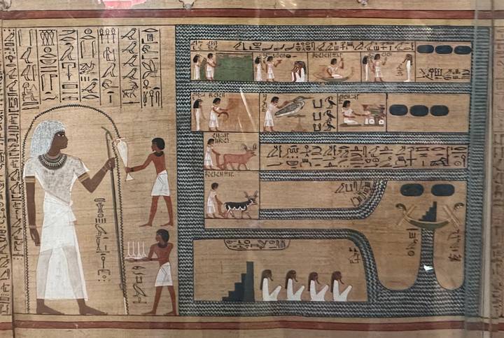 Ancient Egyptian papyrus artwork covered in hieroglyphs and illustrated scenes