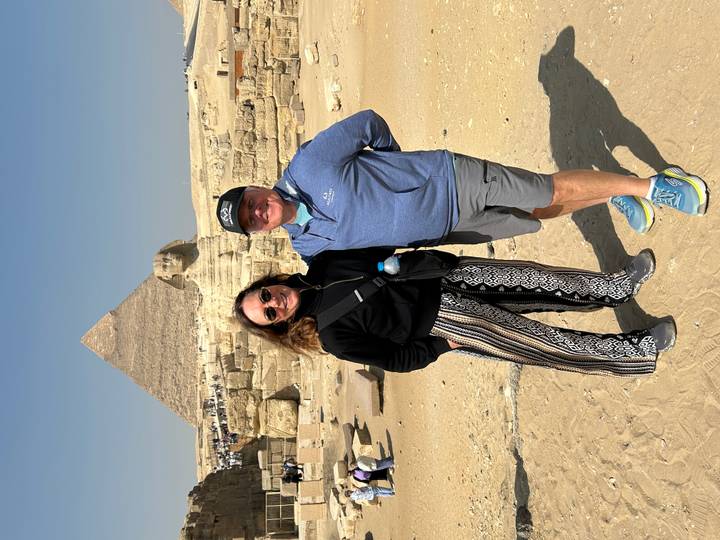 Couple standing before the Great Sphinx with the Great Pyramid rising behind in Giza