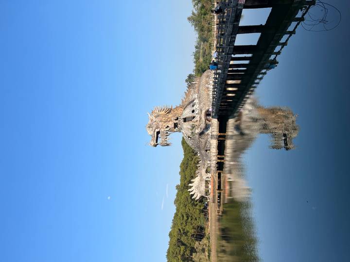 Dragon-shaped concrete structure rises from a reflective lake at Hue's abandoned water park