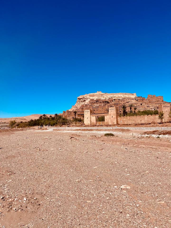 Historic fortified ksar of Ait Benhaddou rising above a dry rocky plain.