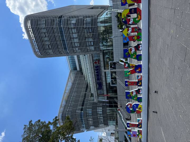 Modern governmental building in San Salvador with colourful 'El Salvador' sign in foreground.