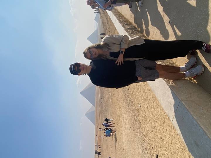 Repeat image of couple posing before the pyramids of Giza.