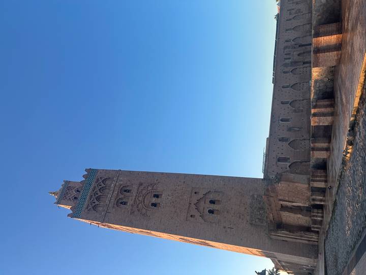 Tall Koutoubia Mosque minaret rising against a clear blue morning sky in Marrakesh.