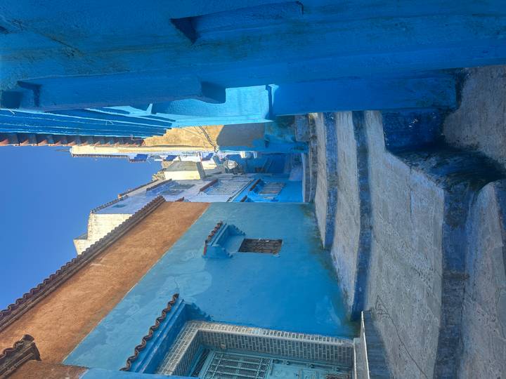 Steep stone steps between vivid blue and ochre walls in the medina of Chefchaouen.