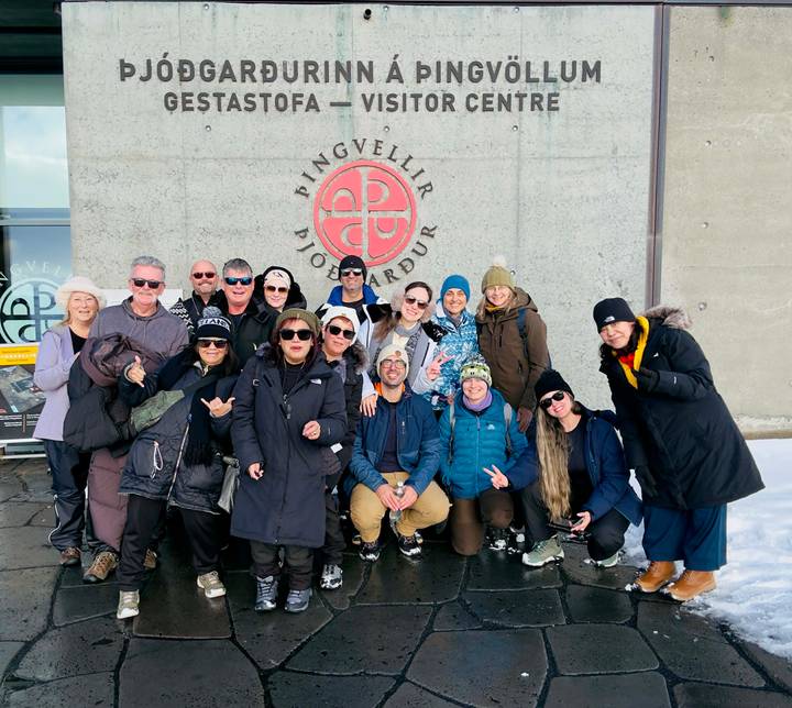 Tour group poses together outside the Þingvellir visitor center on a snowy winter day.