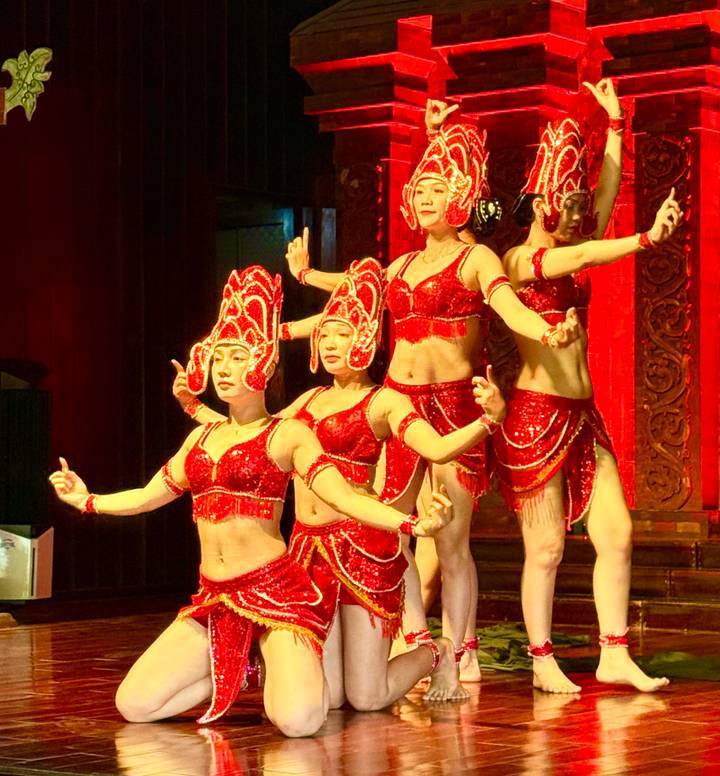 Traditional Vietnamese dancers in sparkling red costumes perform on stage.