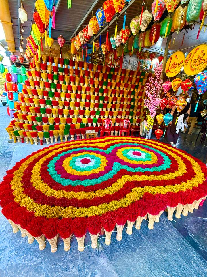Colorful incense stick display arranged in circular patterns at a traditional craft shop in Hue.