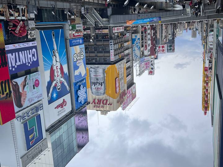 Bustling Dotonbori street lined with towering neon and billboard signs in Osaka.