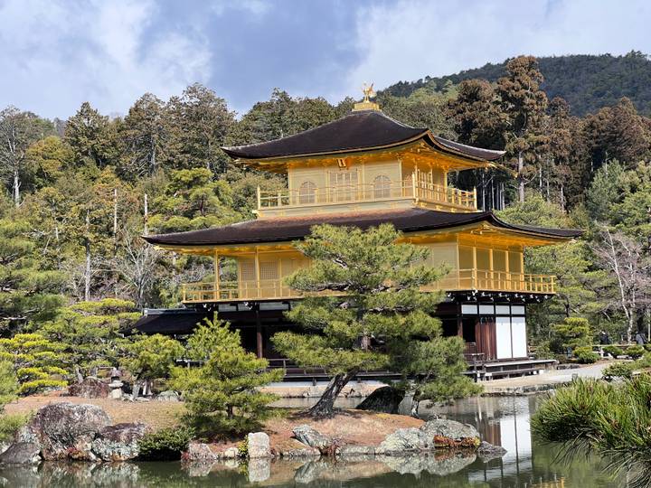 Golden Pavilion (Kinkaku-ji) gleams above a reflective pond surrounded by lush greenery.