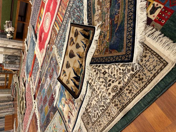 Rows of colourful Turkish carpets laid out in a showroom for display.