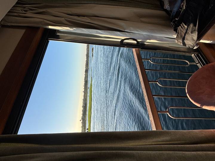 View of the Nile River from a cruise cabin window with railings in the foreground.