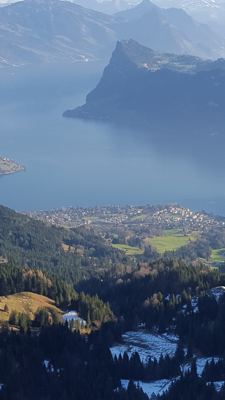 Aerial view of a small town by a lake with mountains.