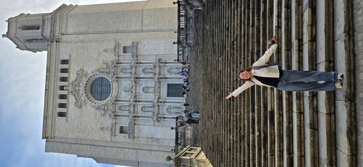 Young traveler posing on the grand staircase leading up to Girona Cathedral’s ornate façade.
