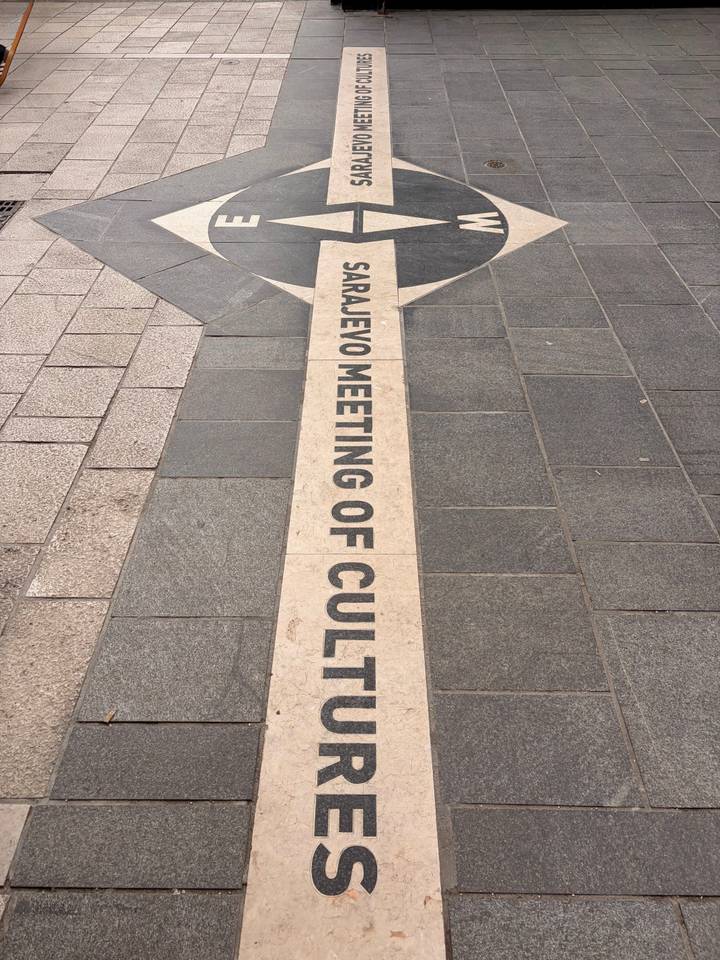 Pavement inscription marking the Sarajevo Meeting of Cultures line on city streets.