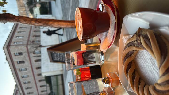 Morning coffee with a chocolate-striped pastry at an outdoor café table in Athens.