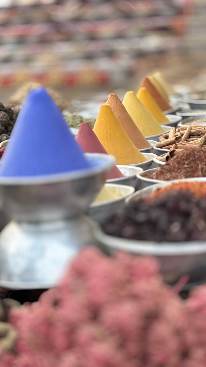 Colorful cones of spices displayed in metal bowls with soft focus artistic effect