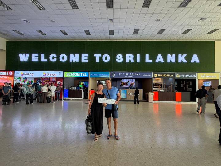 Travellers posing with a welcome sign inside Sri Lanka’s international airport terminal