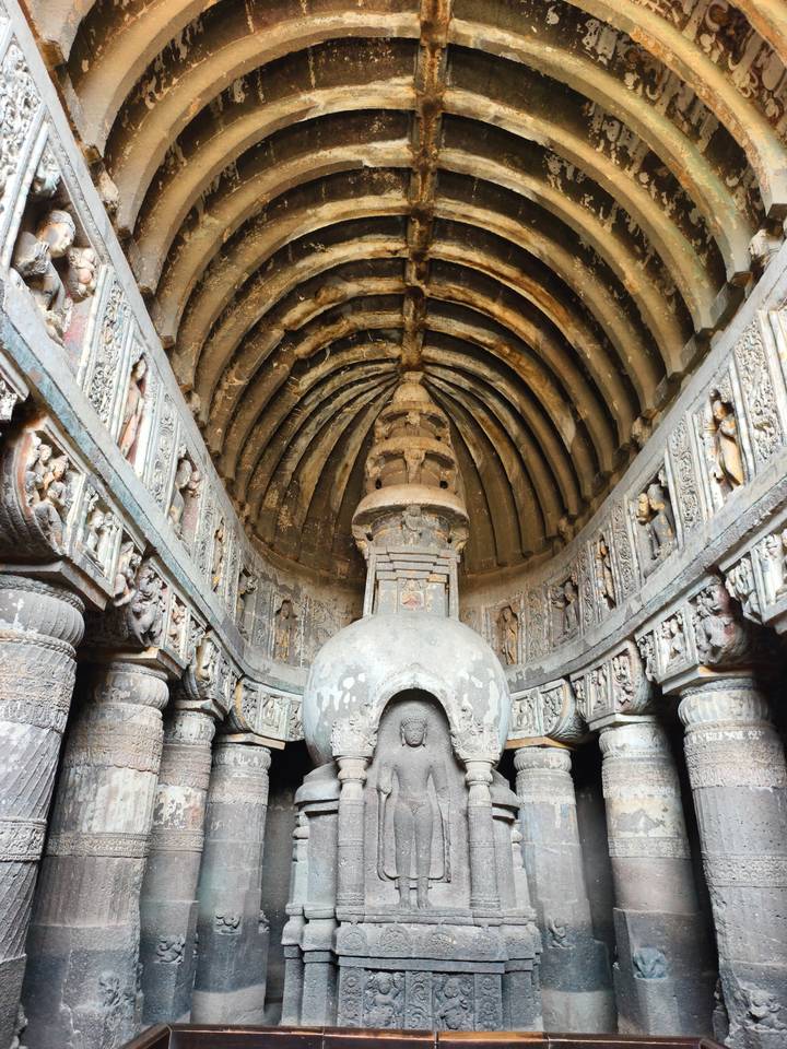 Interior of an ancient chaitya hall with a ribbed stone ceiling and central stupa at Ajanta.