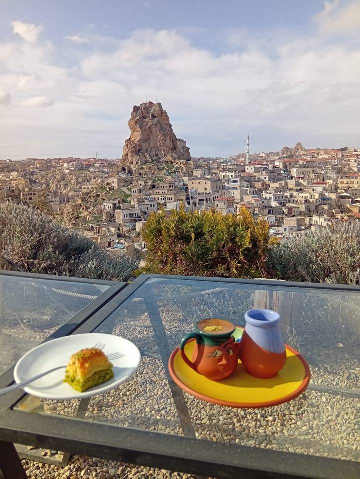 Breakfast table set on a terrace facing Ortahisar’s towering rock castle and surrounding townscape.