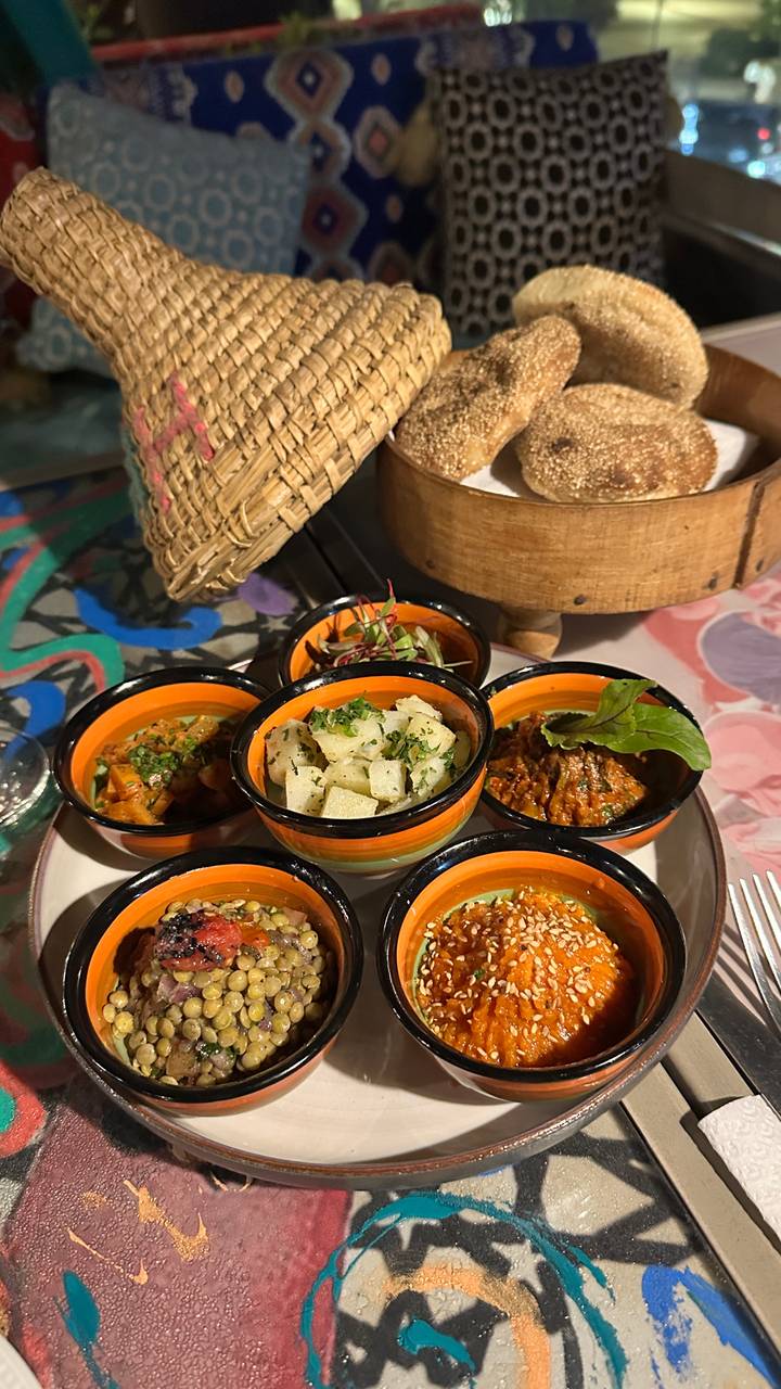 Colorful Moroccan mezze dishes served in small ceramic bowls on a table.