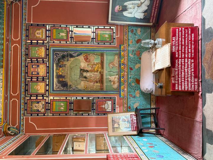 Colorful royal display room with detailed paintings and historical information panels.