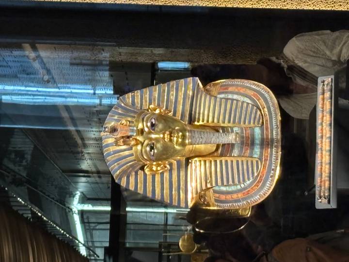 Golden funerary mask of Tutankhamun displayed in a glass case at the museum.