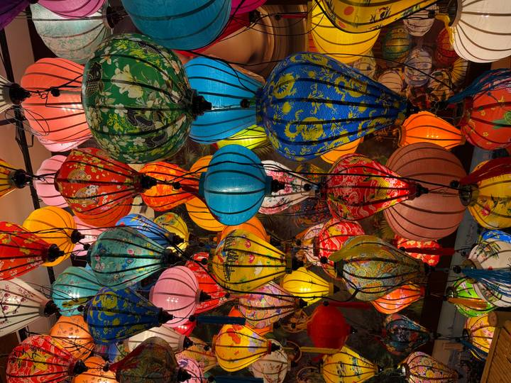 Brightly lit collection of multicolored Vietnamese lanterns hanging closely together