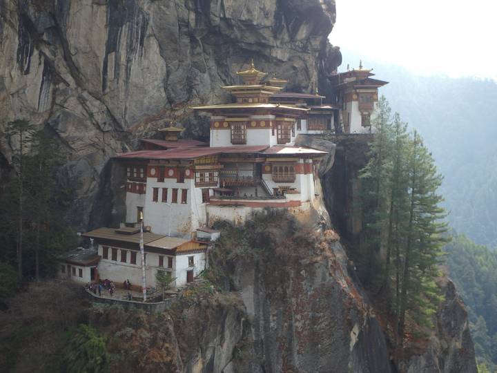 Iconic Tiger's Nest Monastery clinging to a vertical cliff face amid pine forest