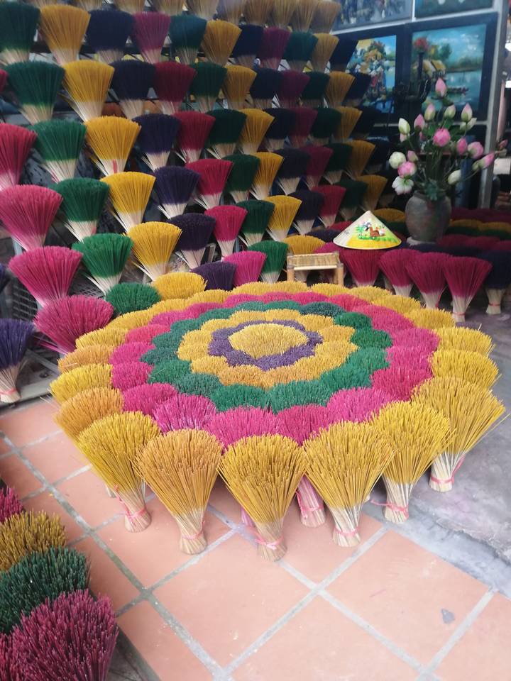 Colorful bundles of incense sticks arranged in concentric flower-like patterns